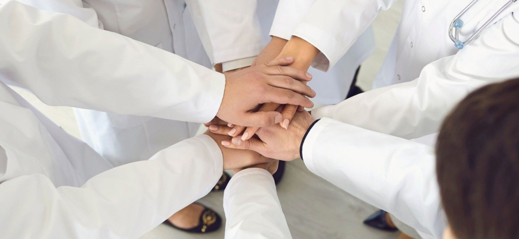 Ομάδα γιατρών βάζουν τα χέρια τους μαζί