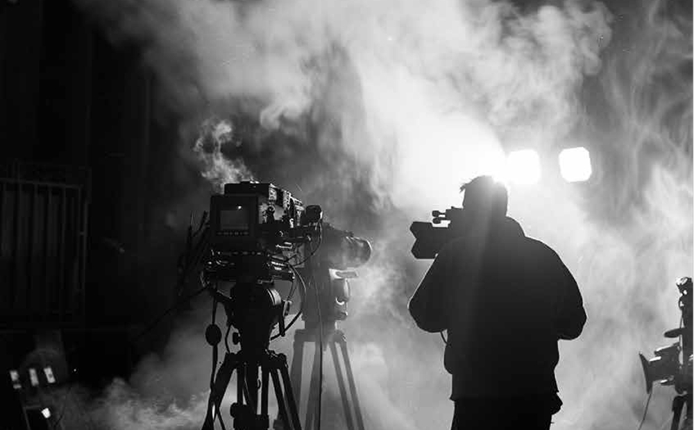 Ένας άνθρωπος κρατάει μια κάμερα σε ένα σετ κινηματογράφησης.