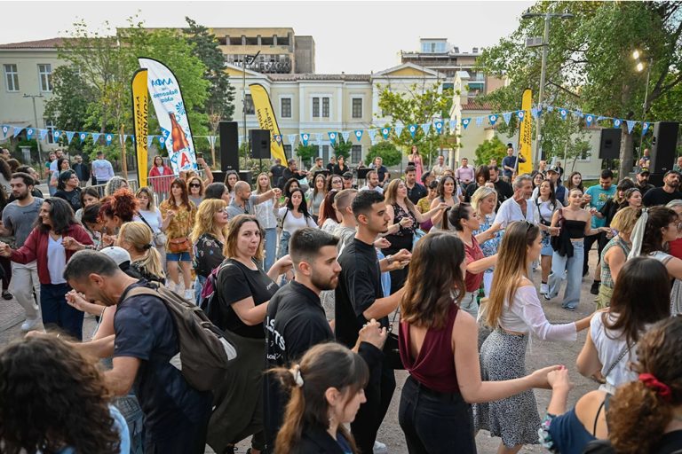 Άνθρωποι χορεύουν παραδοσιακούς χορούς σε κύκλο.