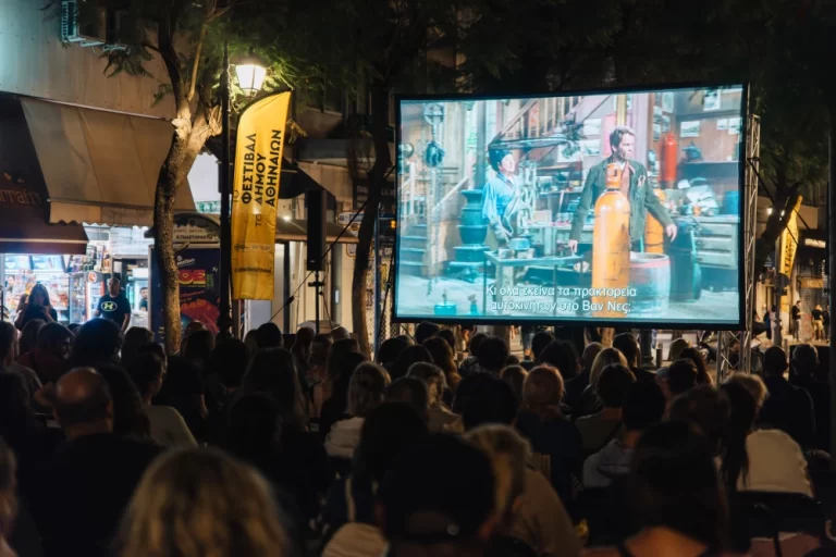 Άνθρωποι παρακολουθούν ταινία στον δρόμο.